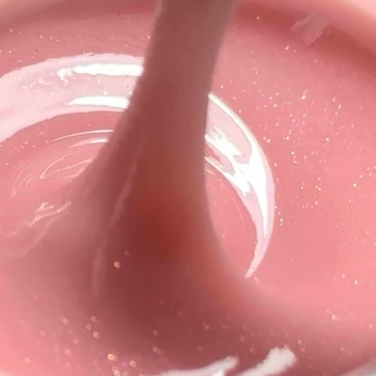 texture  de Polygel liquide Sweet Glow CHRIIS‑ESTHETIC, avec la teinte rose scintillante en arrière-plan, disponible chez mon style mes ongles