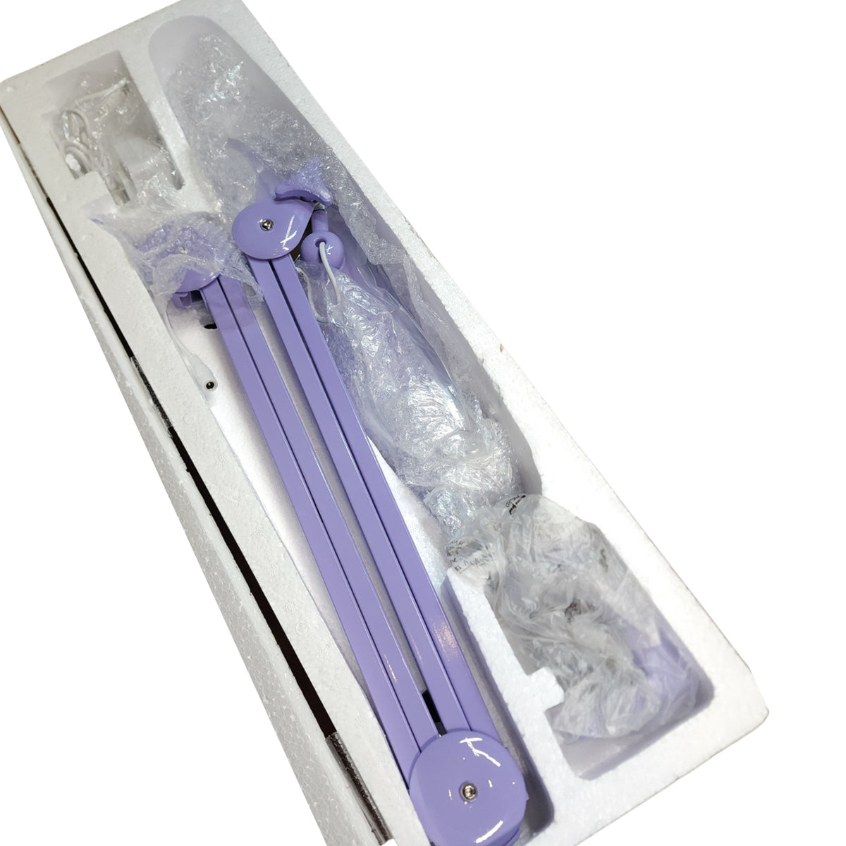 Lampe LED articulée violette et ses accessoires dans leur emballage.