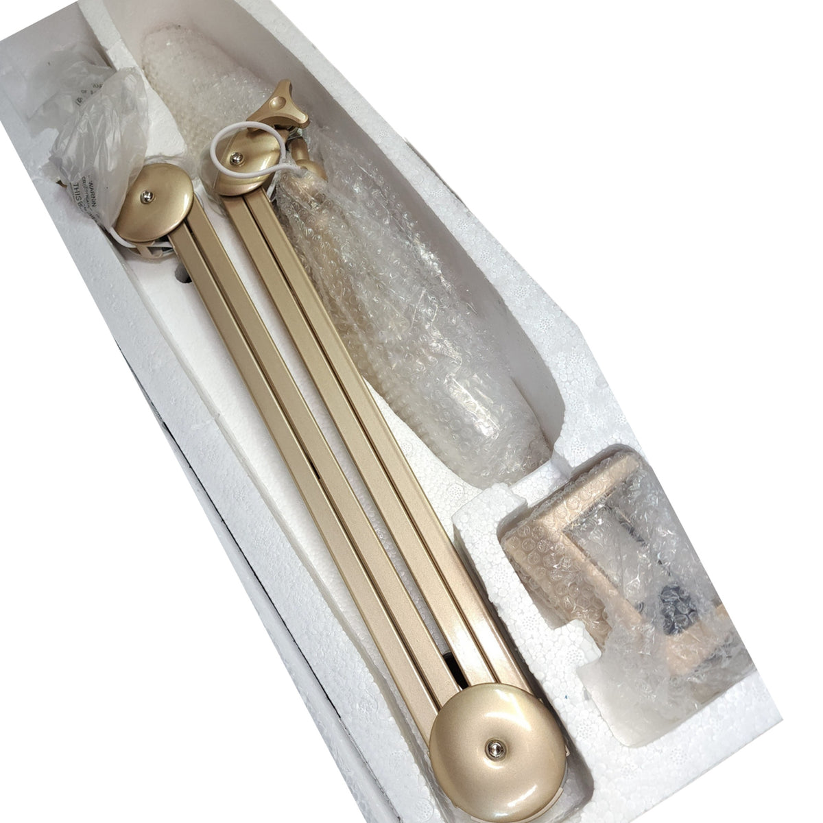 Lampe LED articulée dorée et ses accessoires dans leur emballage.