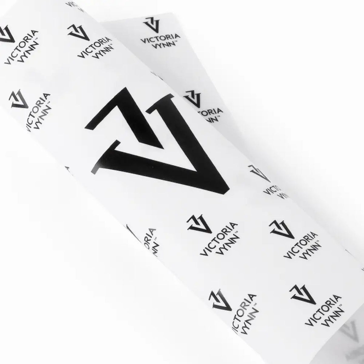 Gros plan du tapis blanc en silicone Victoria Vynn et de ses motifs noirs.