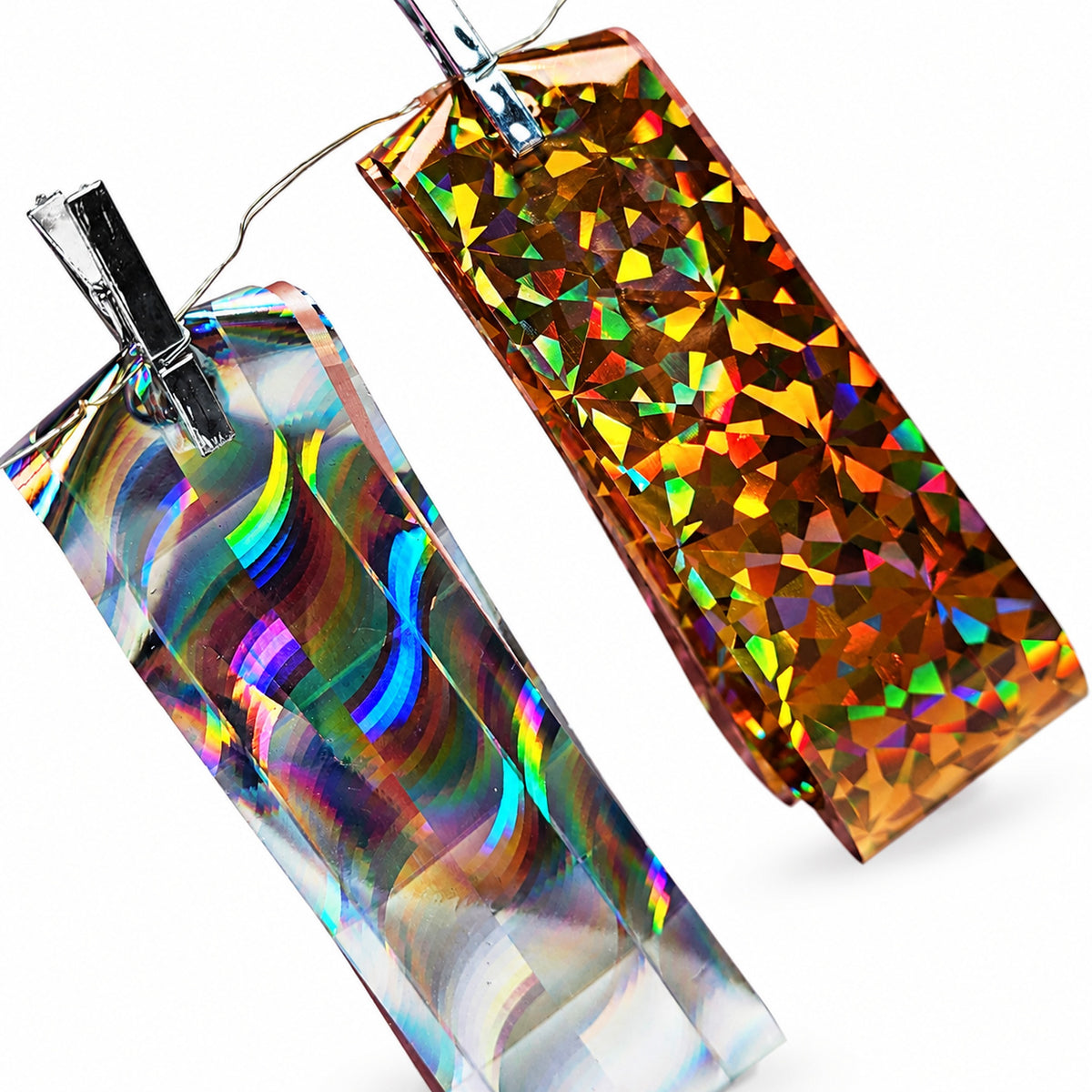 Feuilles de foil holographique argenté multicolore et doré à reflets géométriques.